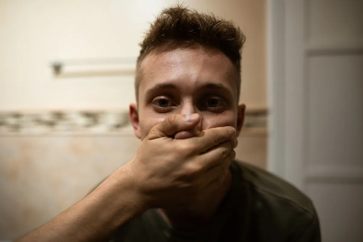 Por qué el trauma nos deja sin palabras: lo que la neurociencia revela sobre el cerebro "atrapado" 2 Joven que se tapa la boca con la mano, imagen sobre cómo el trauma desactiva el área del lenguaje